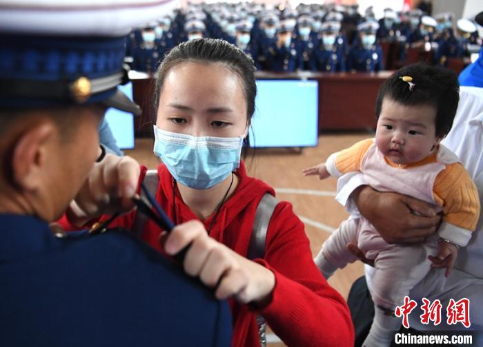 新消防員楊振的妻子彭莉與女兒現(xiàn)場見證丈夫加入“火焰藍(lán)”的神圣時(shí)刻?！⒅铱?攝