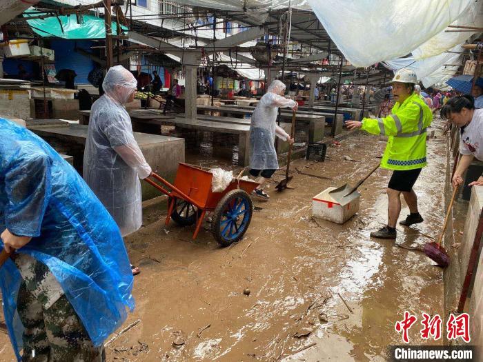 圖為7月26日，暴雨引發(fā)的洪水過境后，重慶萬州區(qū)分水鎮(zhèn)政府干部職工及志愿者清掃淤泥和垃圾?！　≈貞c萬州區(qū)委宣傳部供圖 攝