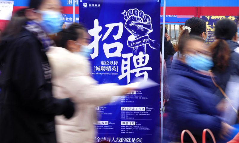 求職者從一家招聘企業(yè)的廣告牌前走過。新華社發(fā)（苑立偉 攝）
